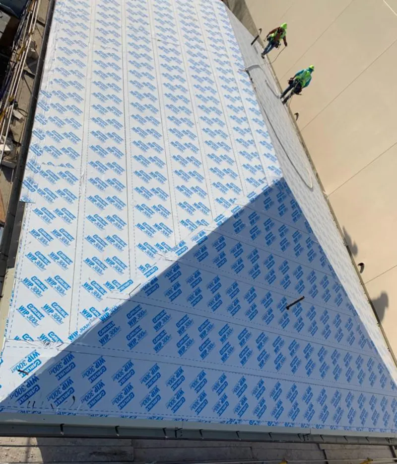 Professional roofers installing underlayment on a metal roof in Flowery Branch